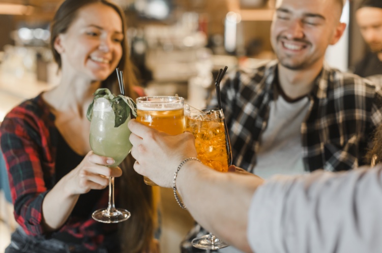 Personas brindando con bebidas en un bar